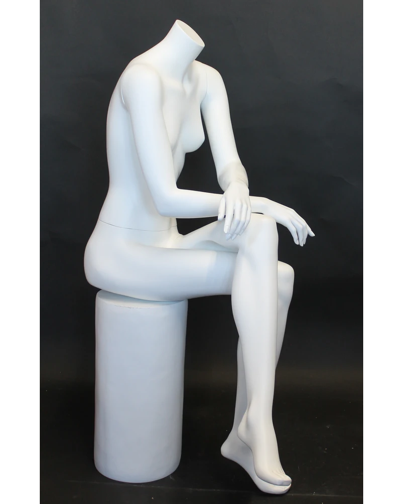 Crossed-leg seated headless female mannequin in matte white